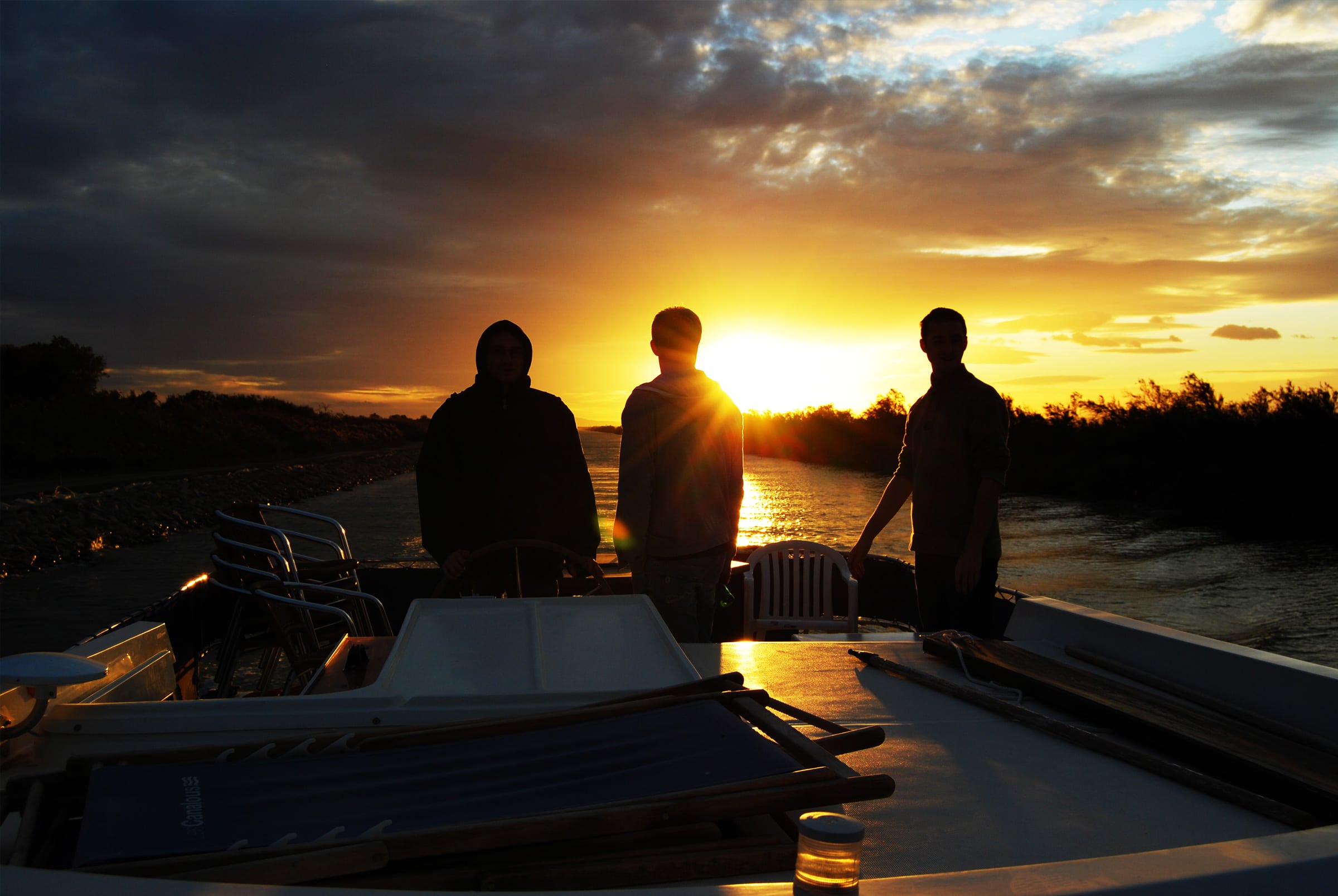 Foto di persone che si divertono su un houseboat al tramonto